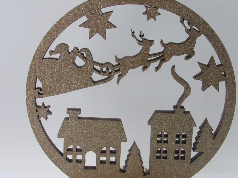 Festive 3-wick candle holder with Santa village scene, glitter details, and striped paper base for seasonal home decor.