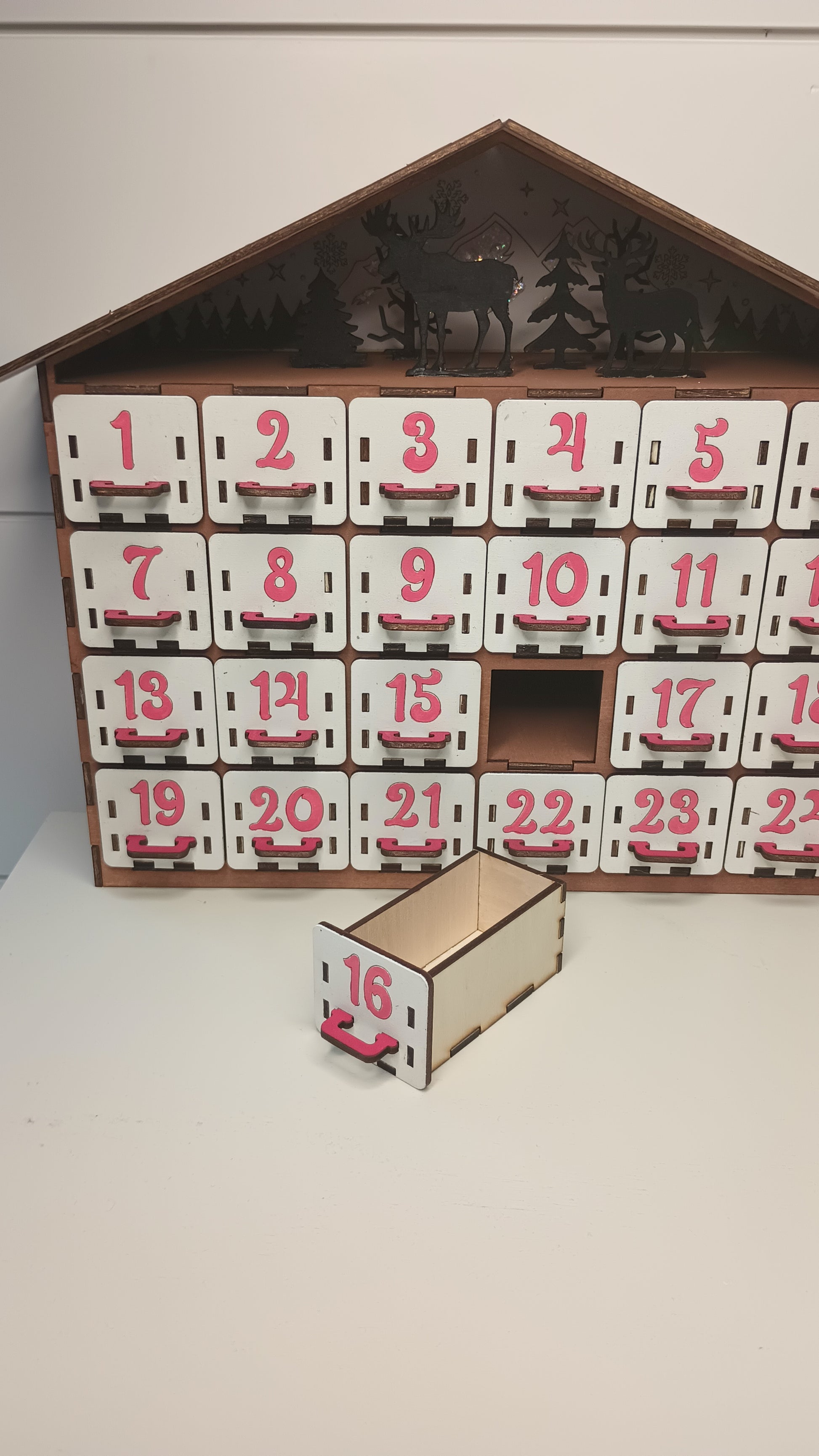 Angled view of rustic Christmas advent calendar showing depth and layered construction.
