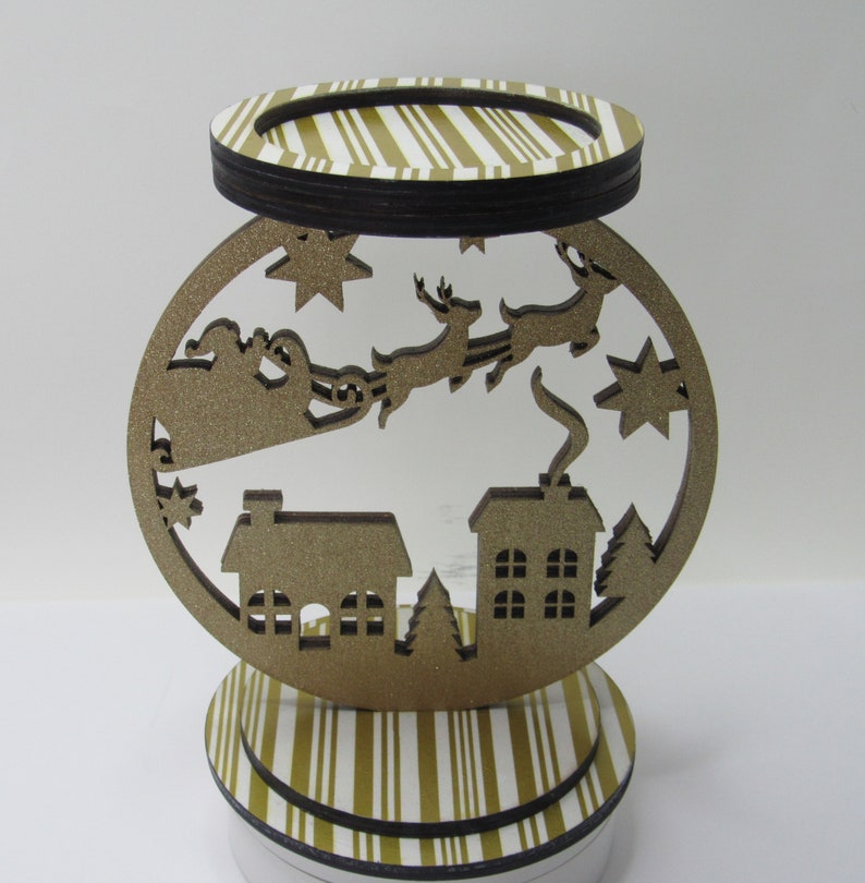 Gold glitter 3-wick candle holder with Santa sleigh and reindeer design, ideal for holiday parties or gift-giving.