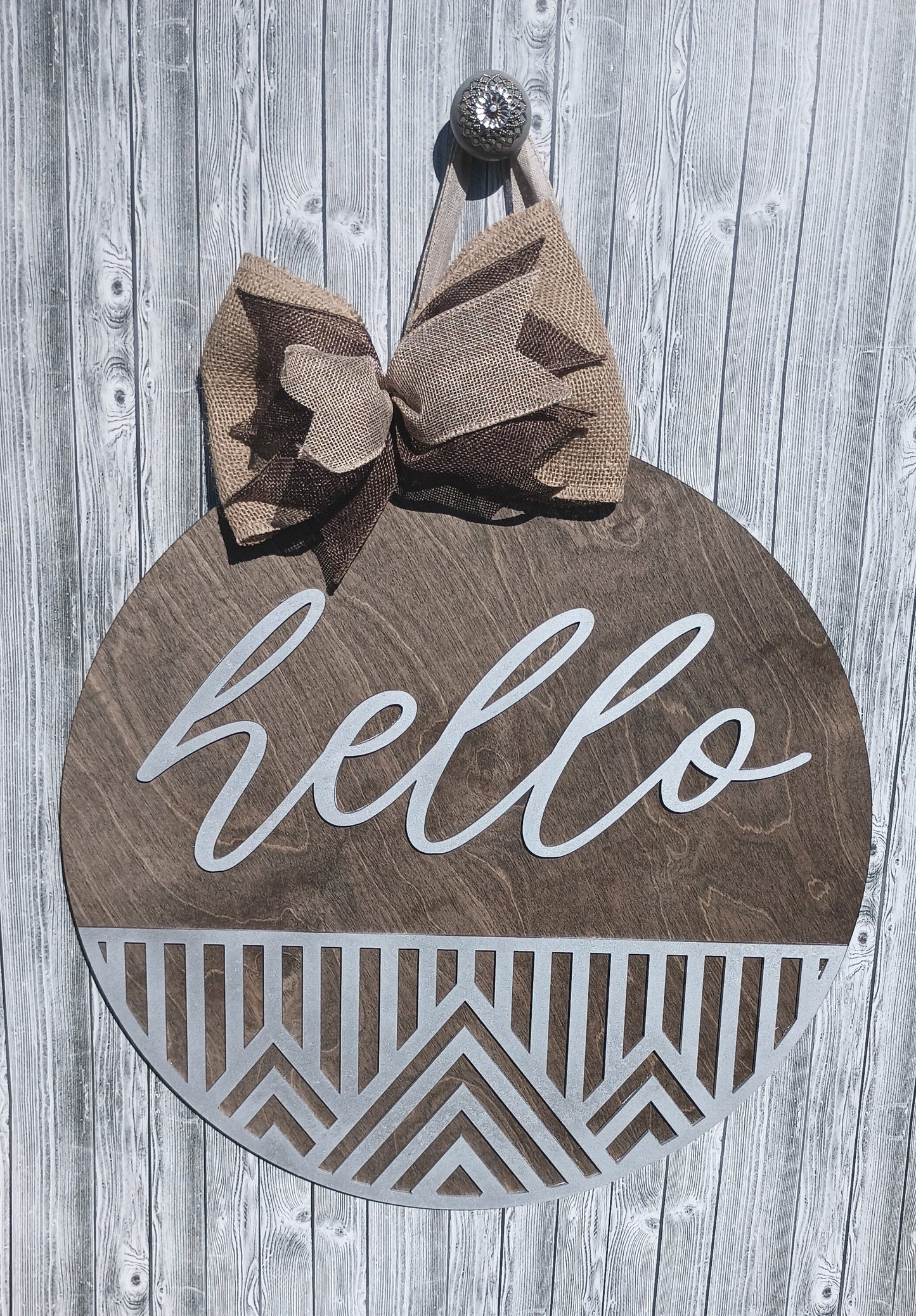 Custom wooden "Hello" door hanger with geometric details and burlap bow for entryway decor.