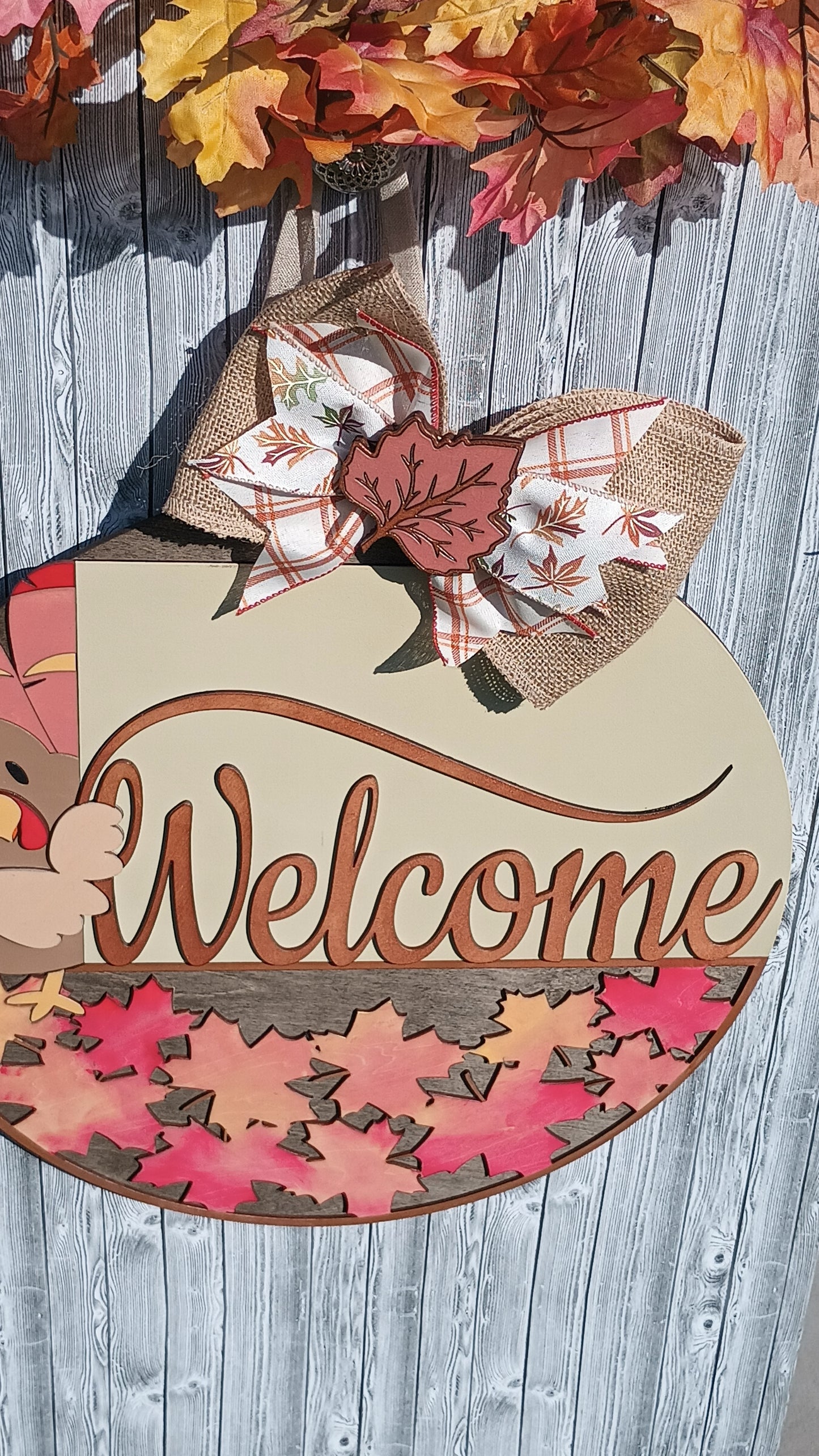 Layered wood Thanksgiving door decor with plaid bow and harvest colors