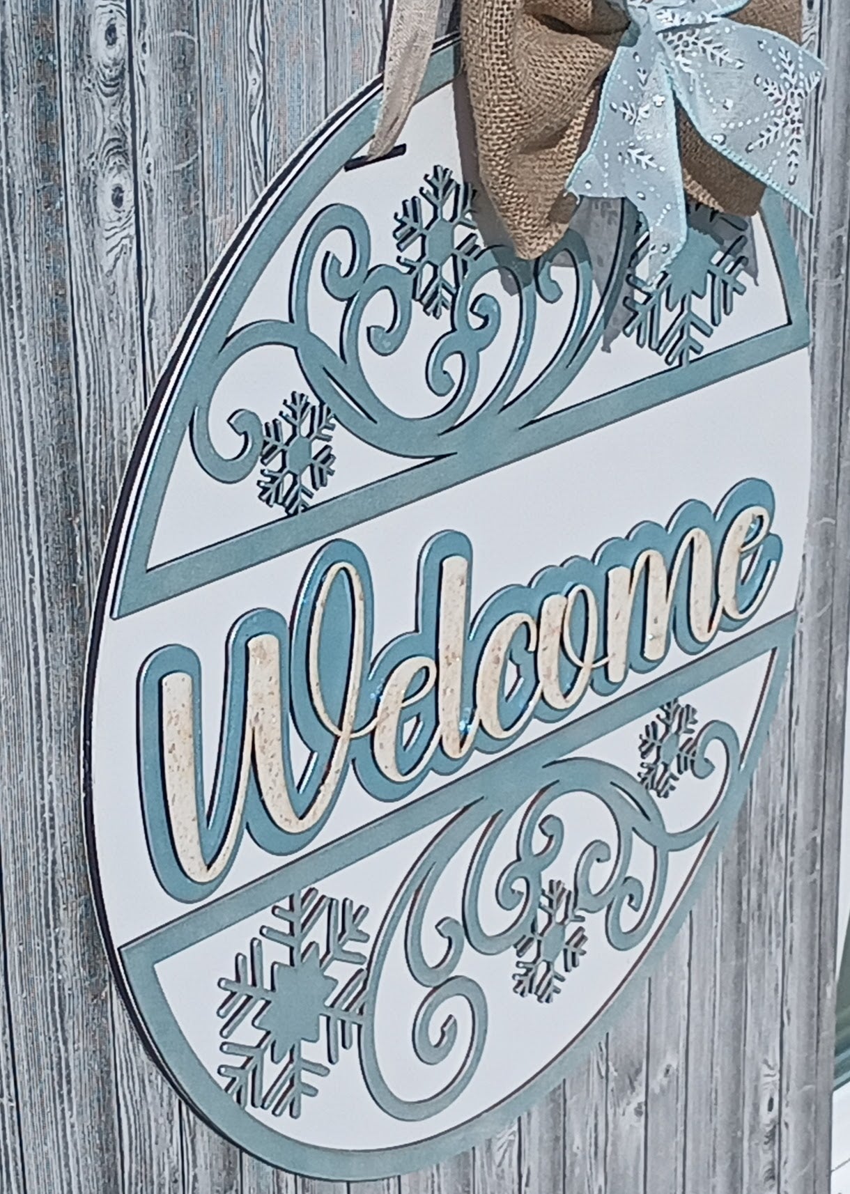 Welcome Winter snowflake door wreath featuring swirling blue patterns, rustic charm, and protective bumpers for your front door.