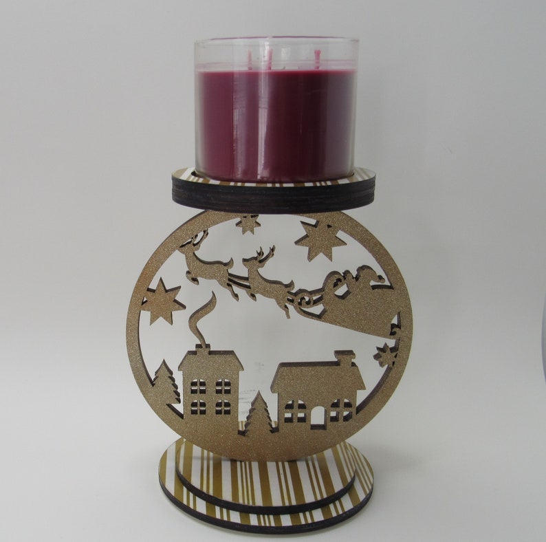 Christmas candle holder with Santa village cutout design, gold glitter accents, and handmade paper details for elegant decor.