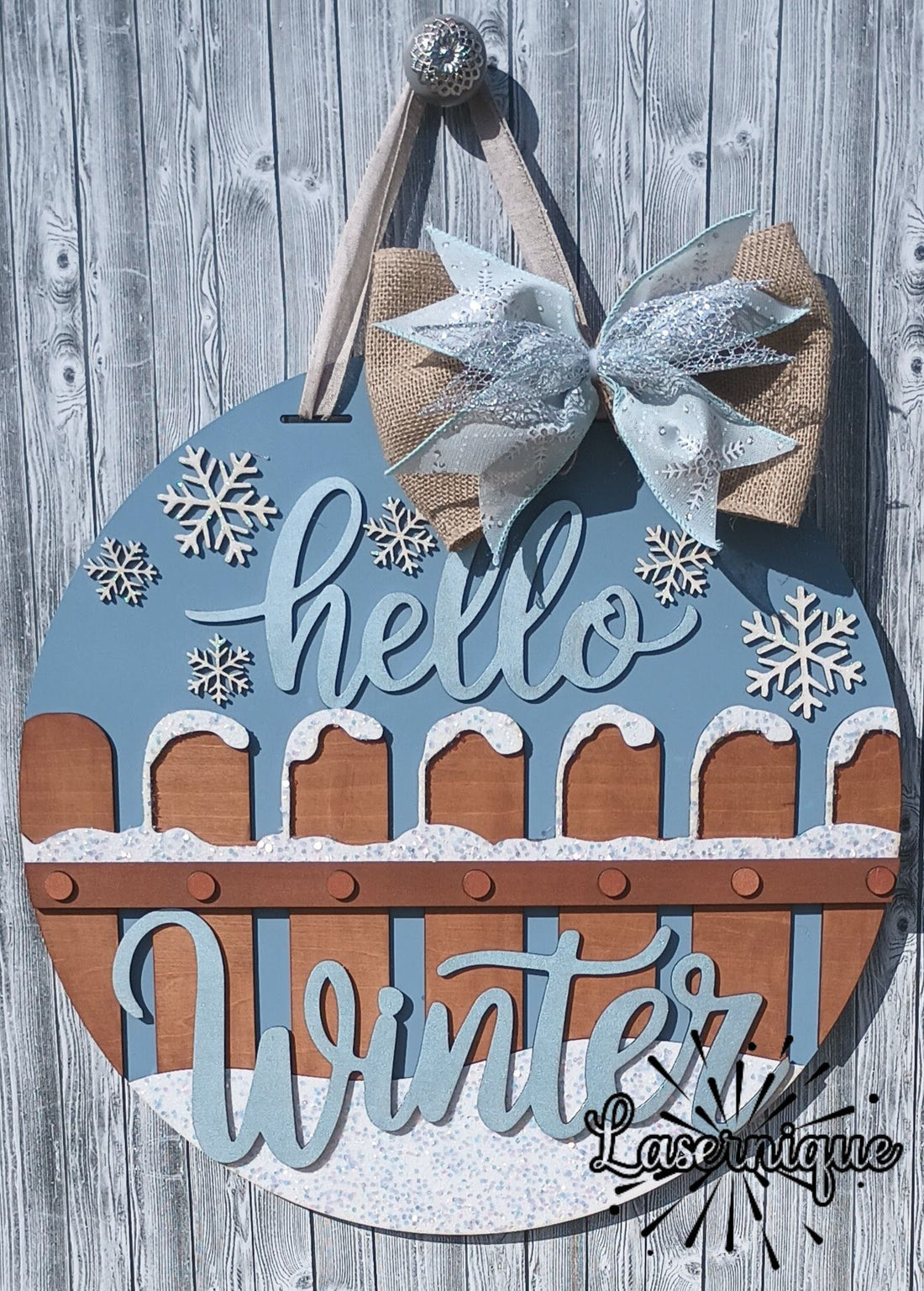 Elegant Hello Winter door hanger with a burlap glitter bow, hand-painted snow accents, and snowflake embellishments for winter front door decor.