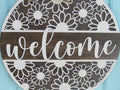 Floral summer wall decor featuring daisy patterns, round wooden sign, and decorative bow for seasonal home accents