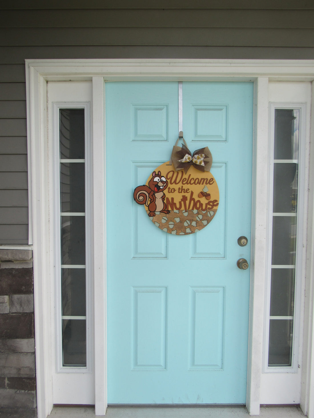 Playful squirrel welcome plaque for front porch, featuring engraved lettering and whimsical woodland flair.
