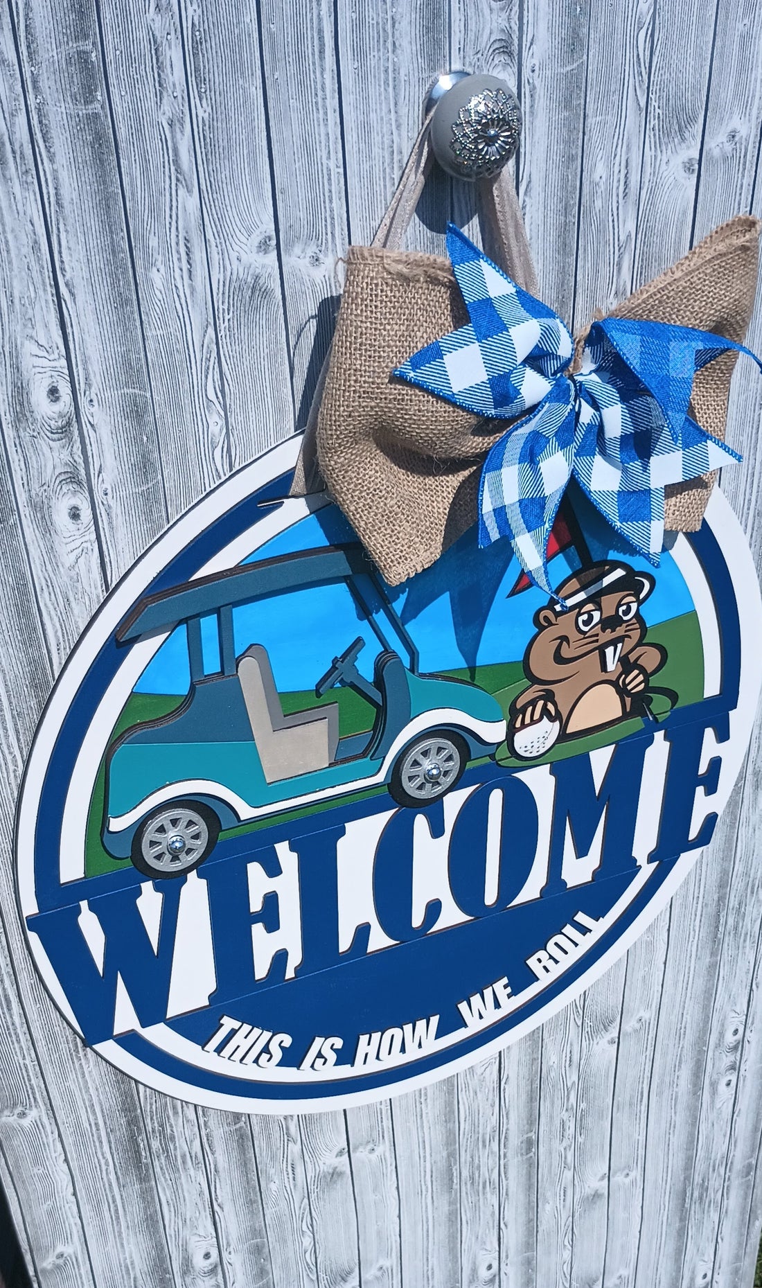 Golf-themed welcome sign with golf cart, flag, and humorous gopher design.