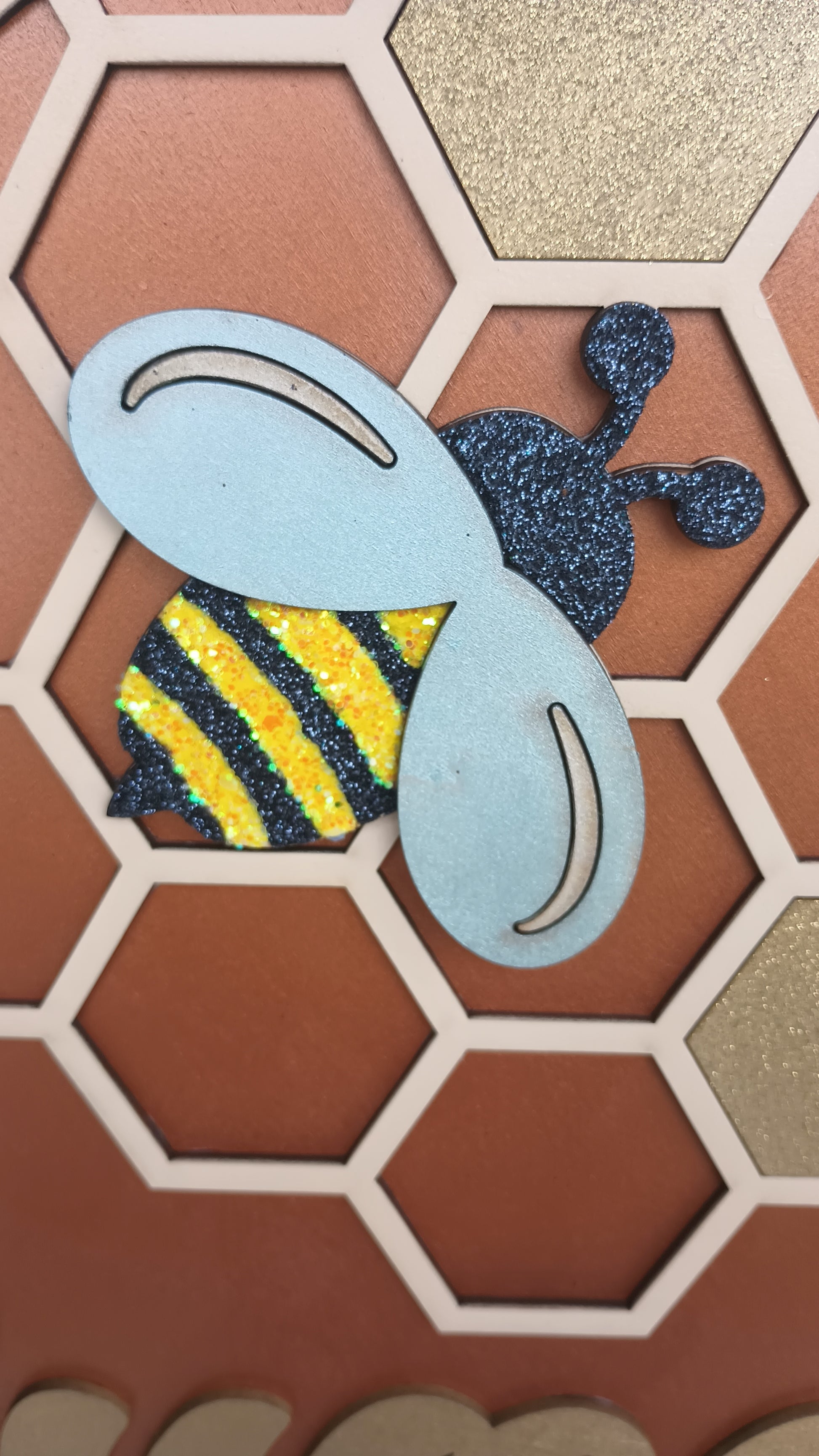 Yellow and brown honeycomb wall sign with bees
