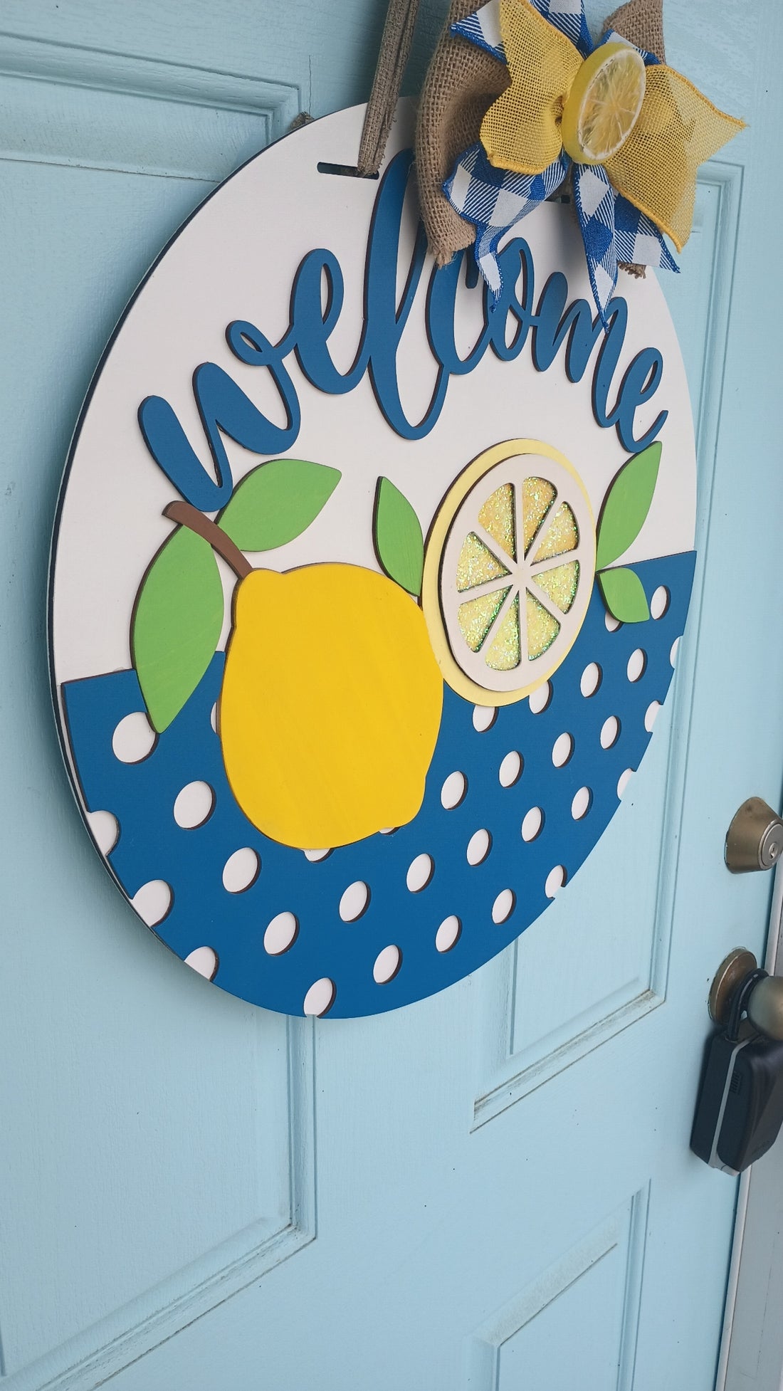 Lemon welcome door sign with bold blue script and polka dot background, handcrafted from premium wood.