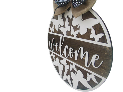 Large round door sign with butterfly cutouts and layered ribbon bow