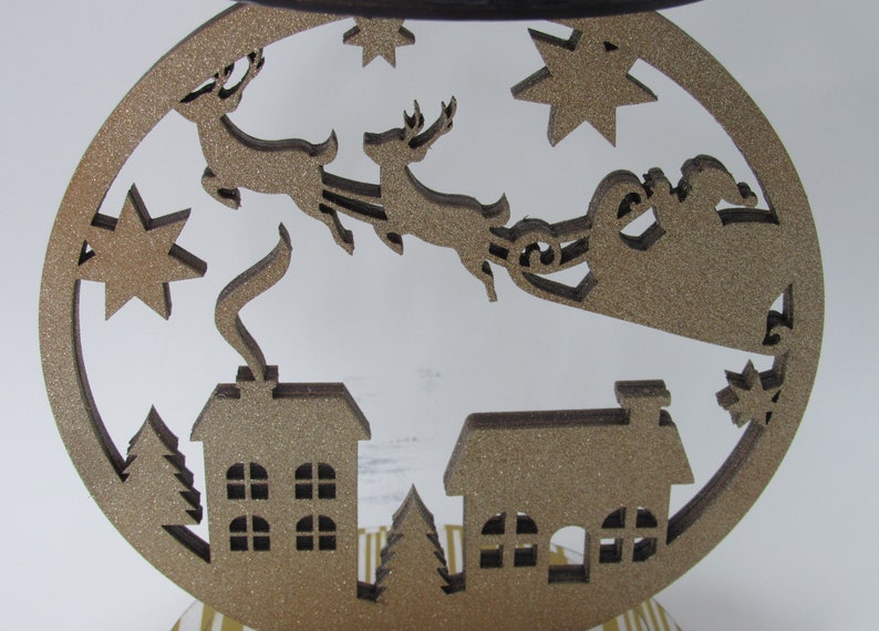 Santa sleigh 3-wick candle holder with village design, glitter accents, and durable craftsmanship for holiday home decor.