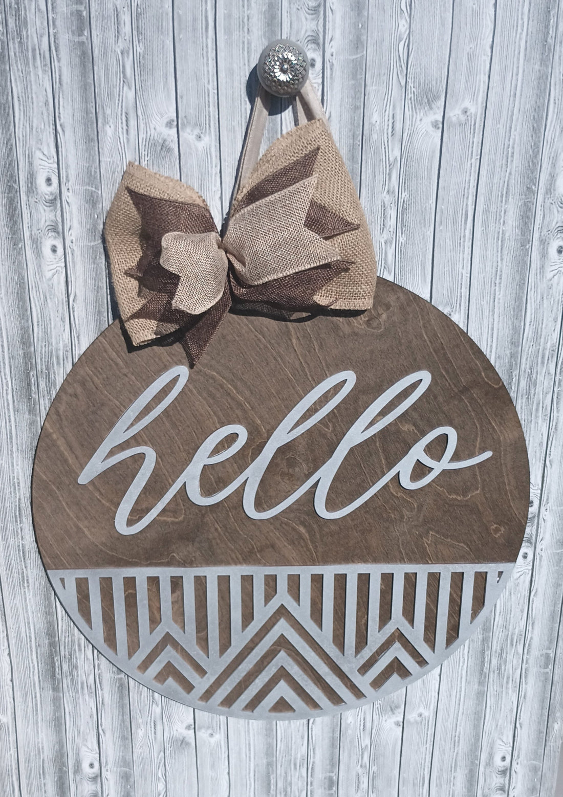 welcome sign with geometric cutout design and farmhouse-style burlap bow.