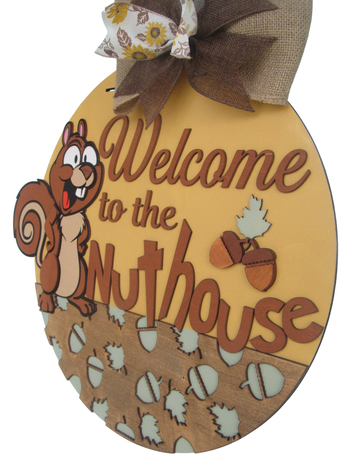 Humorous round welcome sign with nut and leaf cutouts, accented by a sunflower ribbon for seasonal charm.
