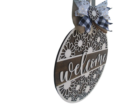 Welcome sign summer door hanger with white decorative daisies, wooden background, and farmhouse bow.