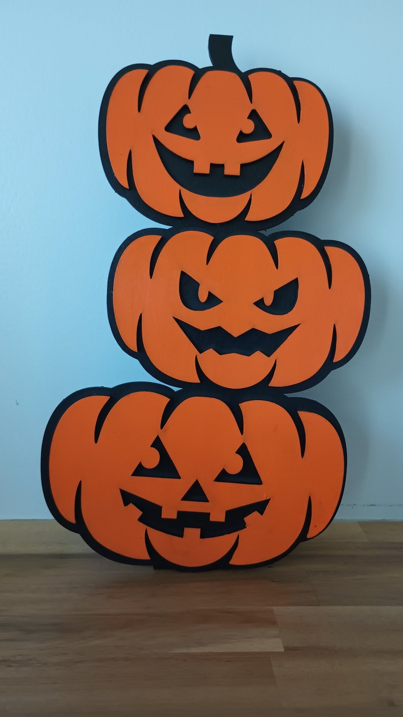 Wooden pumpkin Halloween decoration with carved expressions